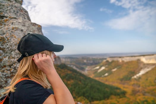 woman backpack on mountain peak looking in beautiful mountain valley in autumn. Landscape with sporty young woman, blu sky in fall. Hiking. Nature.