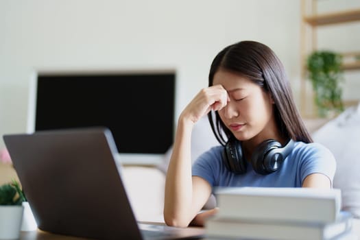 Studying online, beautiful Asian female student show symptoms burnout syndrome student studying online at home.