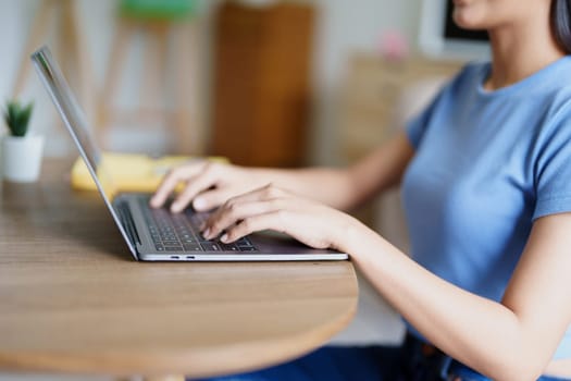 woman wearing headphones on comfortable couch listening to using computer laptop and music