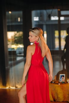 A girl in a red dress moves in a dance meditating indoors . Dynamic dance,