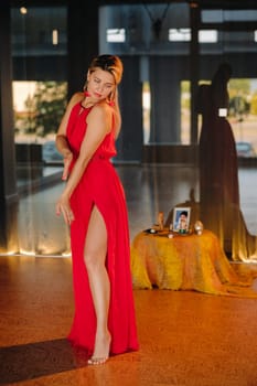 A girl in a red dress moves in a dance meditating indoors . Dynamic dance,