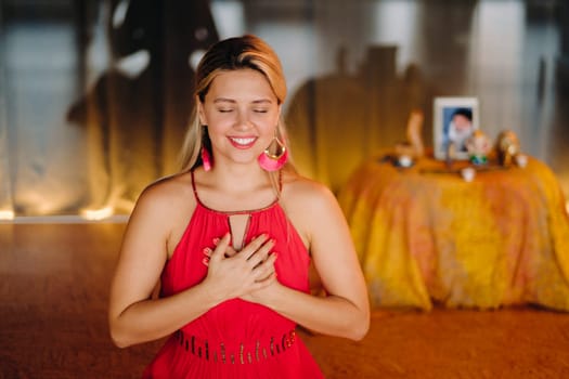 Meditation and concentration. a woman in a red dress, sitting on the floor with her eyes closed, is practicing medicine indoors. Peace and relaxation.