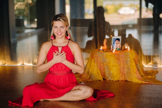 Meditation and concentration. a woman in a red dress sitting on the floor is practicing medicine indoors . Calm and relaxation.