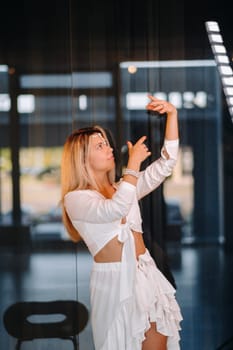 Beautiful smiling girl in a white dress dancing in the gym.