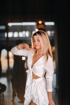 Beautiful smiling girl in a white dress dancing in the gym.