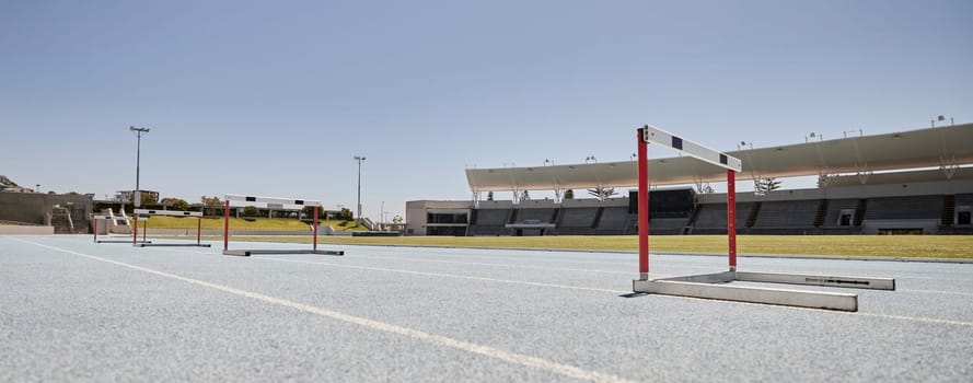 Stadium, hurdles and sports event for exercise, olympics and training with no people, space and mockup. Sport, venue and hurdling workout at an empty track for workout, healthy lifestyle and venue.