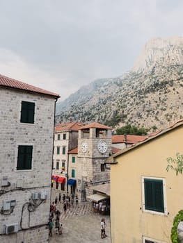 Ancient stone clock tower among old houses. Kotor, Montenegro. High quality photo