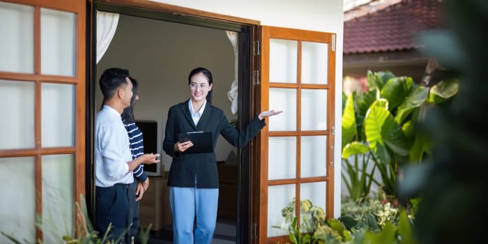 Couple lover with real estate agent visiting house for sale. husband and wife who plan property investment looking at lovely modern spacious home.