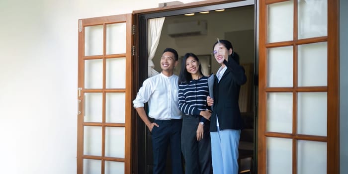 Couple lover with real estate agent visiting house for sale. husband and wife who plan property investment looking at lovely modern spacious home.