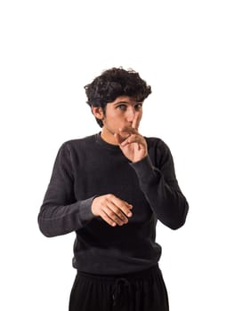 Young man doing hush sign with finger over his mouth, looking at camera, isolated on white, silencing