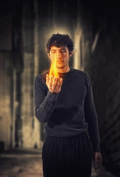 A man holding a glowing flame in his hands