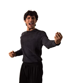 A young attractive man in a black shirt and pants singing boldly or celebrating victory, isolated on white