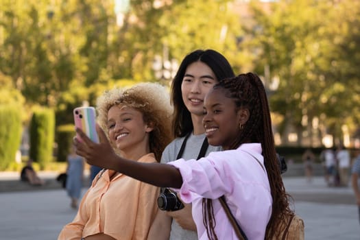 Group of three multi ethnic friends taking selfie with a smart phone.