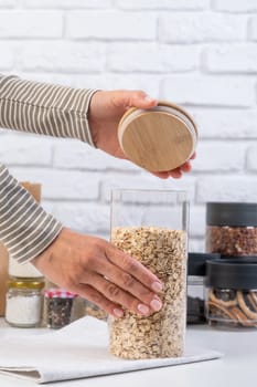 woman Reusing Glass Jars To Store Dried Food Living Sustainable Lifestyle At Home, copy space