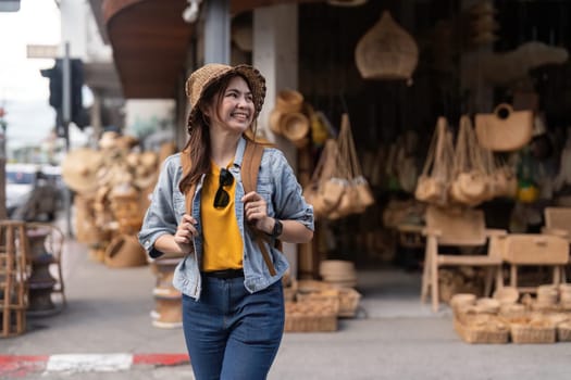 Young beautiful woman traveling at the local market during vacation. Tourist women travel in Chiang mai enjoy shopping market during holidays, backpacker traveller.