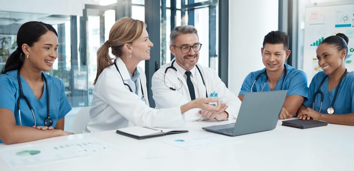 Doctor with laptop, team and health, meeting and professional collaboration on medical innovation and healthcare policy. Teamwork in conference room, diversity and group discussion at the clinic