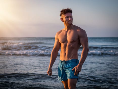 Handsome, hot young bodybuilder in the sea showing his muscular torso and arms - Muscular and fit young bodybuilder in the sea