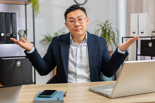 I don't know what to say. Confused business man working on laptop at office workplace. Freelancer feeling embarrassed about ambiguous question, having doubts, no answer idea, being clueless, uncertain