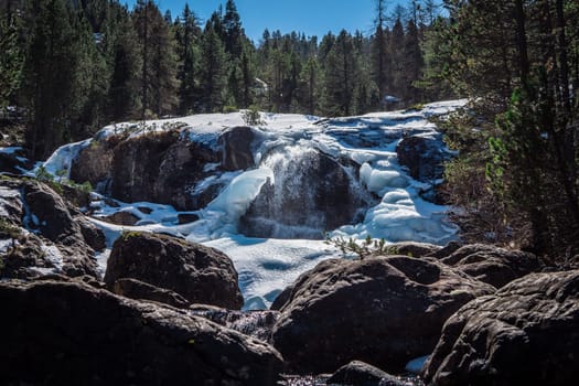 A waterfall in the middle of a snowy forest