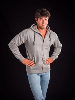 A man in a gray hoodie is posing for a picture