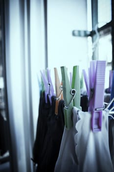 Clothespins holding clothes on clothesline. Various colors. No people