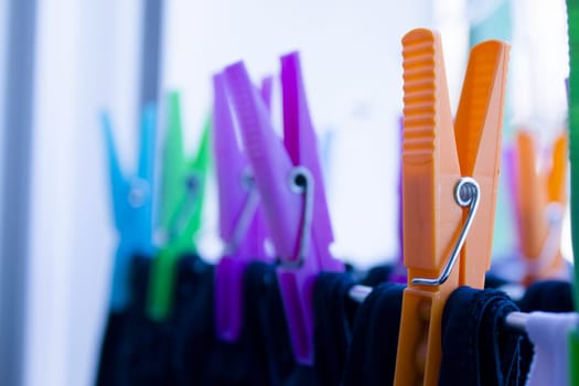 Clothespins holding clothes on clothesline. Various colors. No people