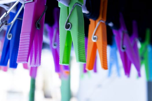 Clothespins holding clothes on clothesline. Various colors. No people