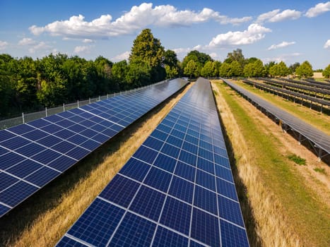 Rows of solar collectors and solar panels of a solar power plant in a solar park on an agricultural field near Sonne, Germany