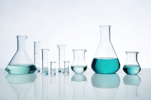 Laboratory equipment beakers and flasks with blue liquids with backlight in different group. AI Generated