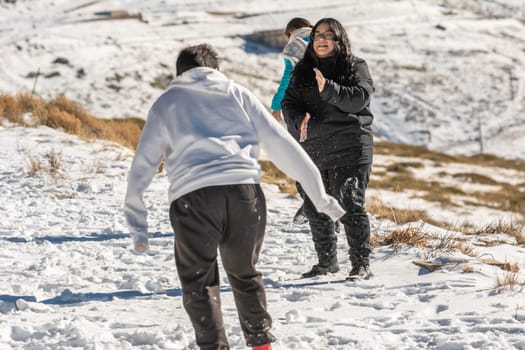 latin brunette girl playing in the snow at the ski resort in granada,sierra nevada , andalucia spain