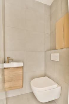 a bathroom with a white toilet and wooden cabinet in the corner next to it is a wall mounted mirror on the wall