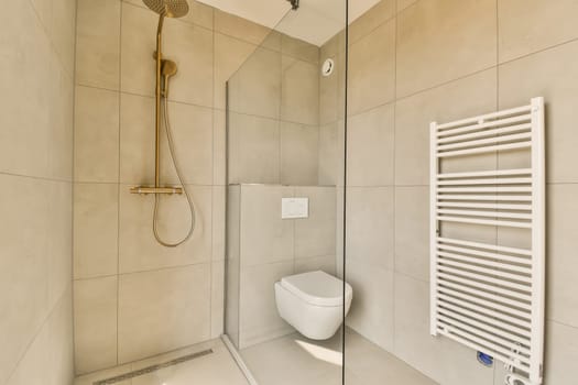 a bathroom with a toilet, shower and towel rack on the wall next to it is a glass enclosed shower door