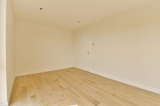 an empty room with white walls and wood flooring on the right side of the room, there is a door in the corner