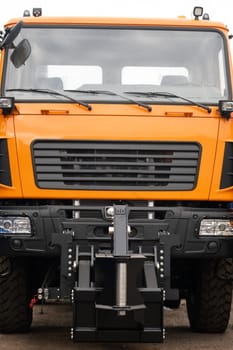 Close-up of the cab of an orange-colored truck.