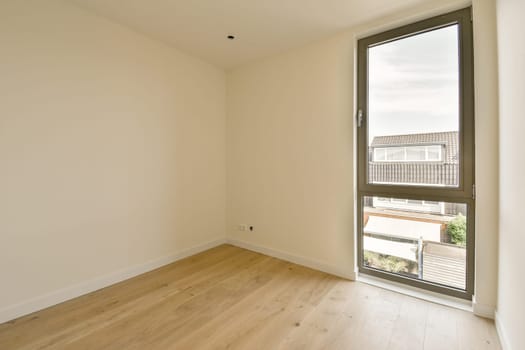 an empty room with wood flooring and large window looking out onto the cityscapearrons com
