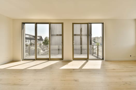 an empty living room with sliding glass doors and hardwood flooring in the middle part of the room is white