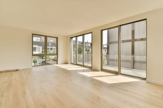 an empty living room with wood flooring and sliding glass doors looking out onto the street in front of the house
