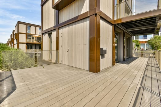 an outside area with wood flooring and metal railings on the side of a house that has been painted white