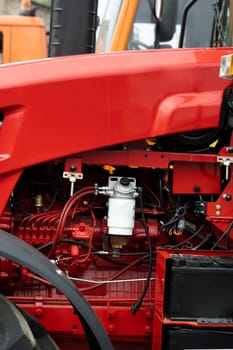 Close-up of part of the new red tractor. Vehicle assembly.