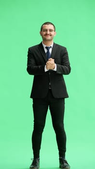 full-length portrait of a young man. standing isolated on green background.