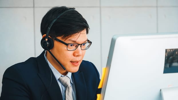 Business people wearing headset working in office to support remote customer or colleague. Call center, telemarketing, customer support agent provide service on telephone video conference call. Jivy