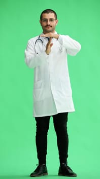 male doctor in a white coat on a green background shows a sign take a break.