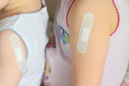 Brother and sister with patch on forearm after tuberculosis vaccine bcg