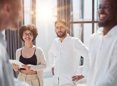 Glad to work with you. Young modern men in smart casual wear shaking hands and smiling while working in the creative office