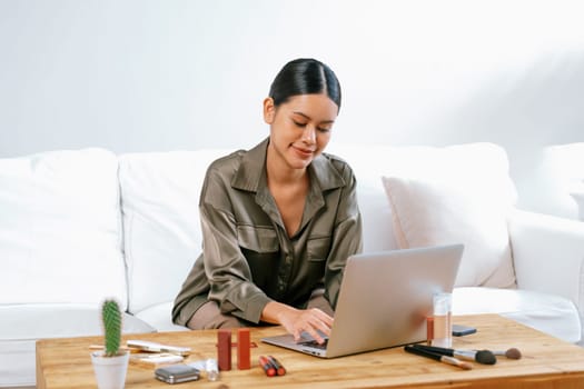 Young happy Asian woman buy product by online shopping at home while ordering items from the internet with credit card online payment protected by uttermost cyber security from online store platform