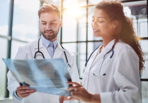 Concentrated male doctor looking at x-ray picture of spine