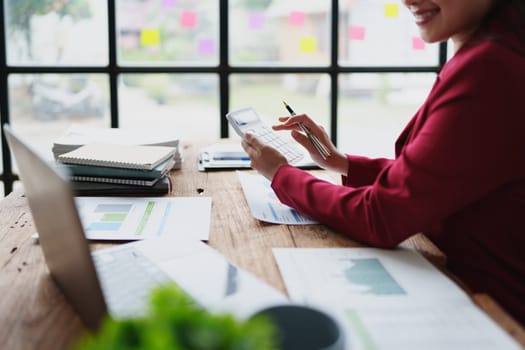 Young asian female work with financial papers at home count on calculator before paying taxes receipts online, planning budget glad to find chance for economy saving money, audit concepts.