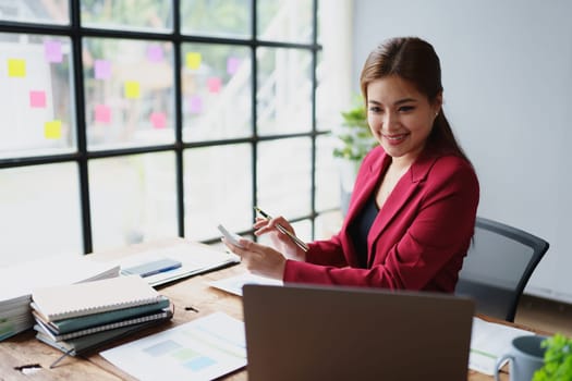 Young asian female work with financial papers at home count on calculator before paying taxes receipts online, planning budget glad to find chance for economy saving money, audit concepts.