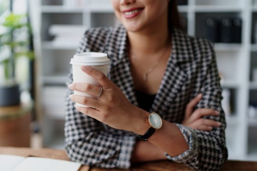 Portrait of a business woman talking on the computer and drinking coffee.