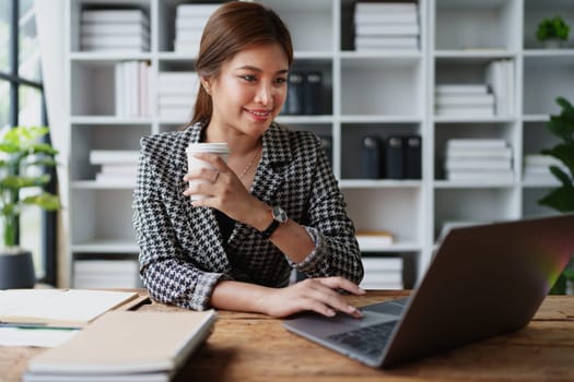 Portrait of a business woman talking on the computer and drinking coffee.